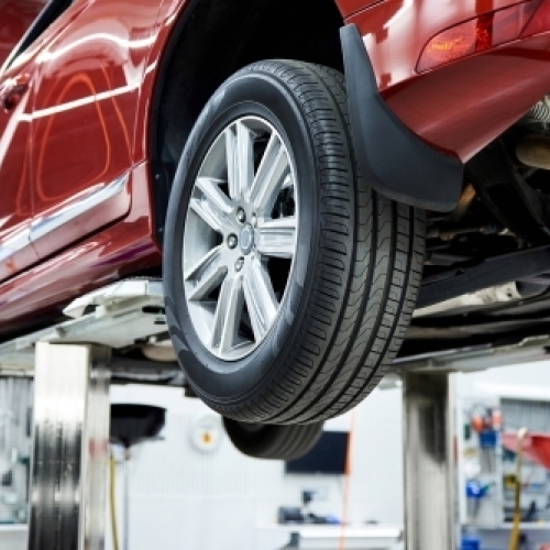 Bil på lift til dækskifte og serviceeftersyn på autoværksted i Frederikssund – nye dæk og sikkerhedstjek
